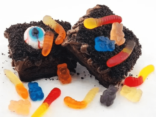 A brownie with chocolate frosting and gummy bears.