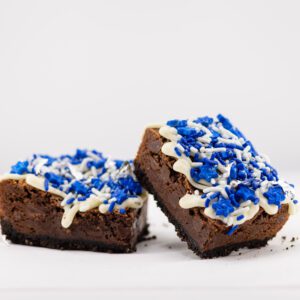 Two pieces of brownie with blue sprinkles on top.