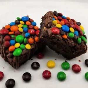 A close up of two brownies with candy on top