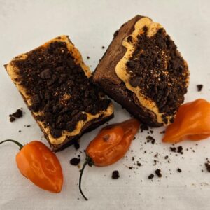Spicy Feisty Monster Habanero brownies with crushed cookie topping served with orange habanero peppers.
