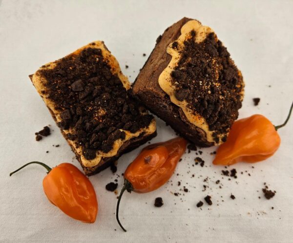 Spicy Feisty Monster Habanero brownies with crushed cookie topping served with orange habanero peppers.